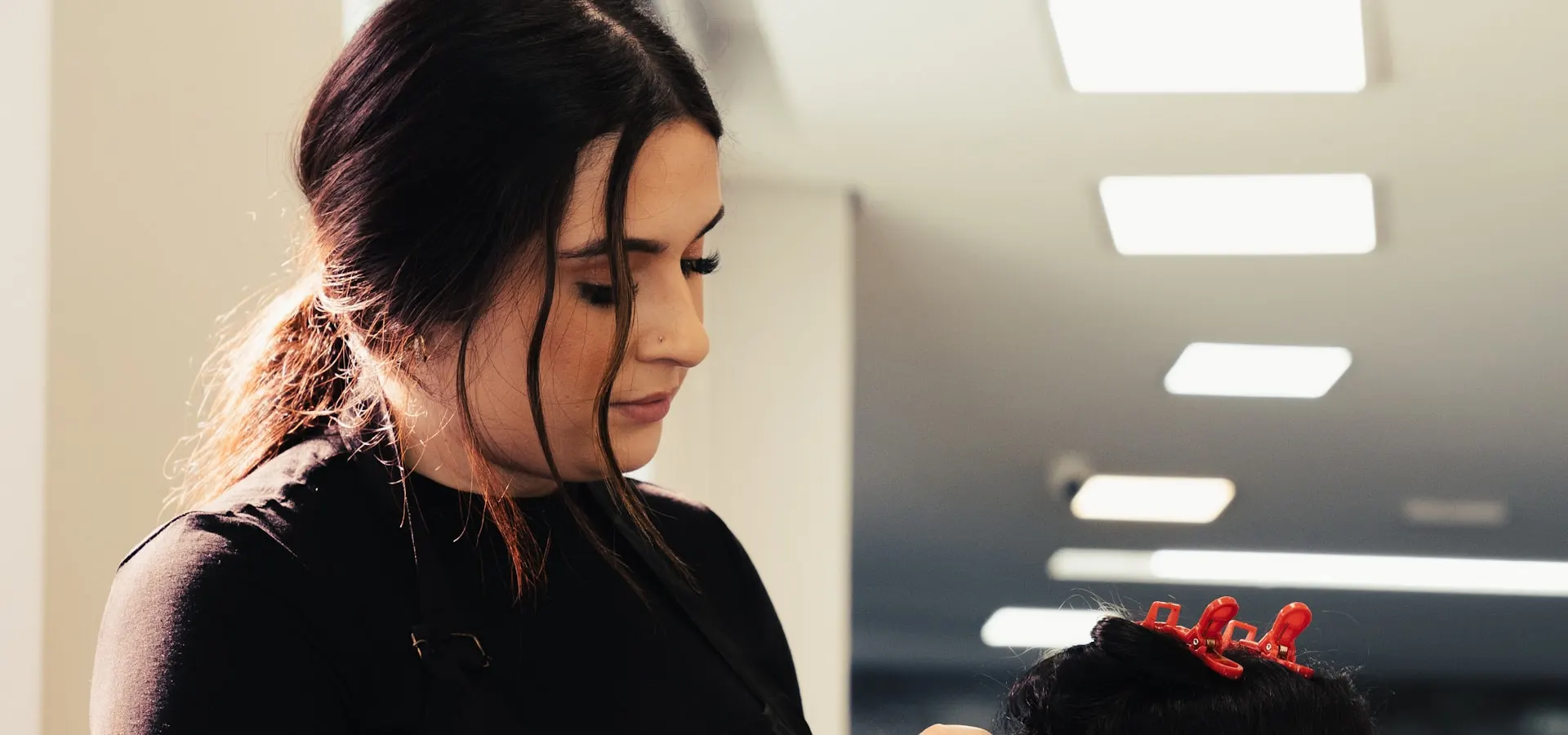 A hair stylist working with a client in a salon
