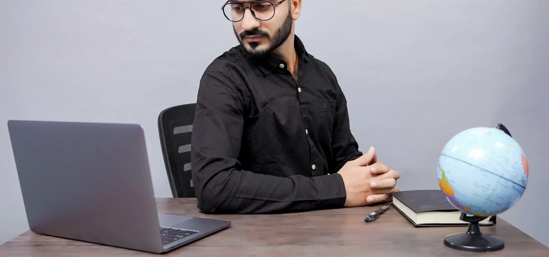 A travel consultant working at a desk with a globe