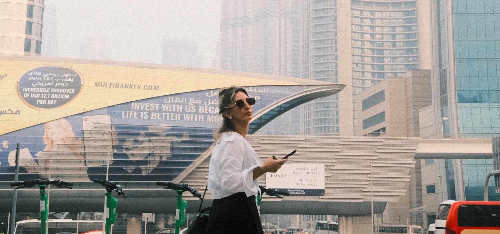 A business professional walking in Dubai with the Burj Khalifa in view