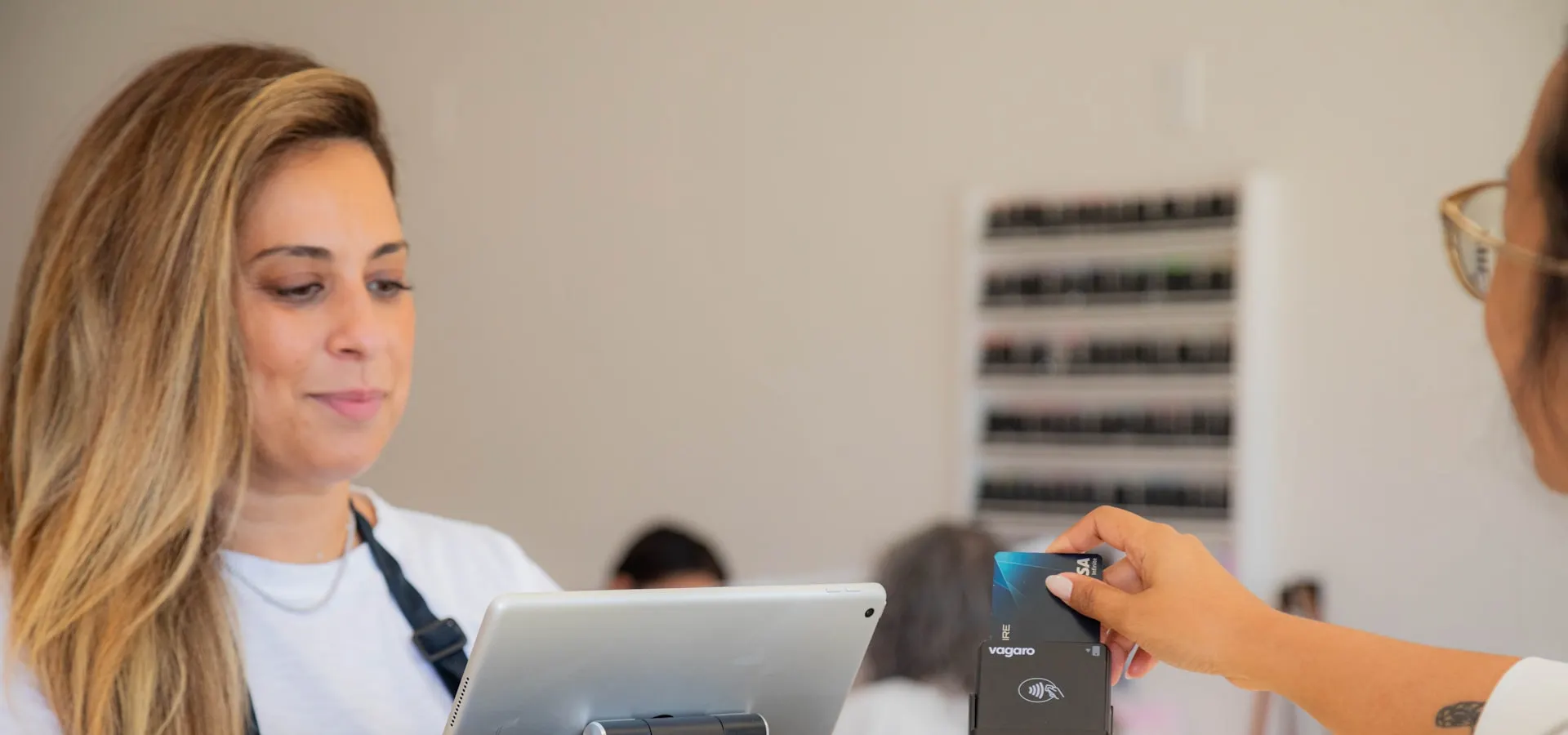 A business owner processing a client booking at the front desk