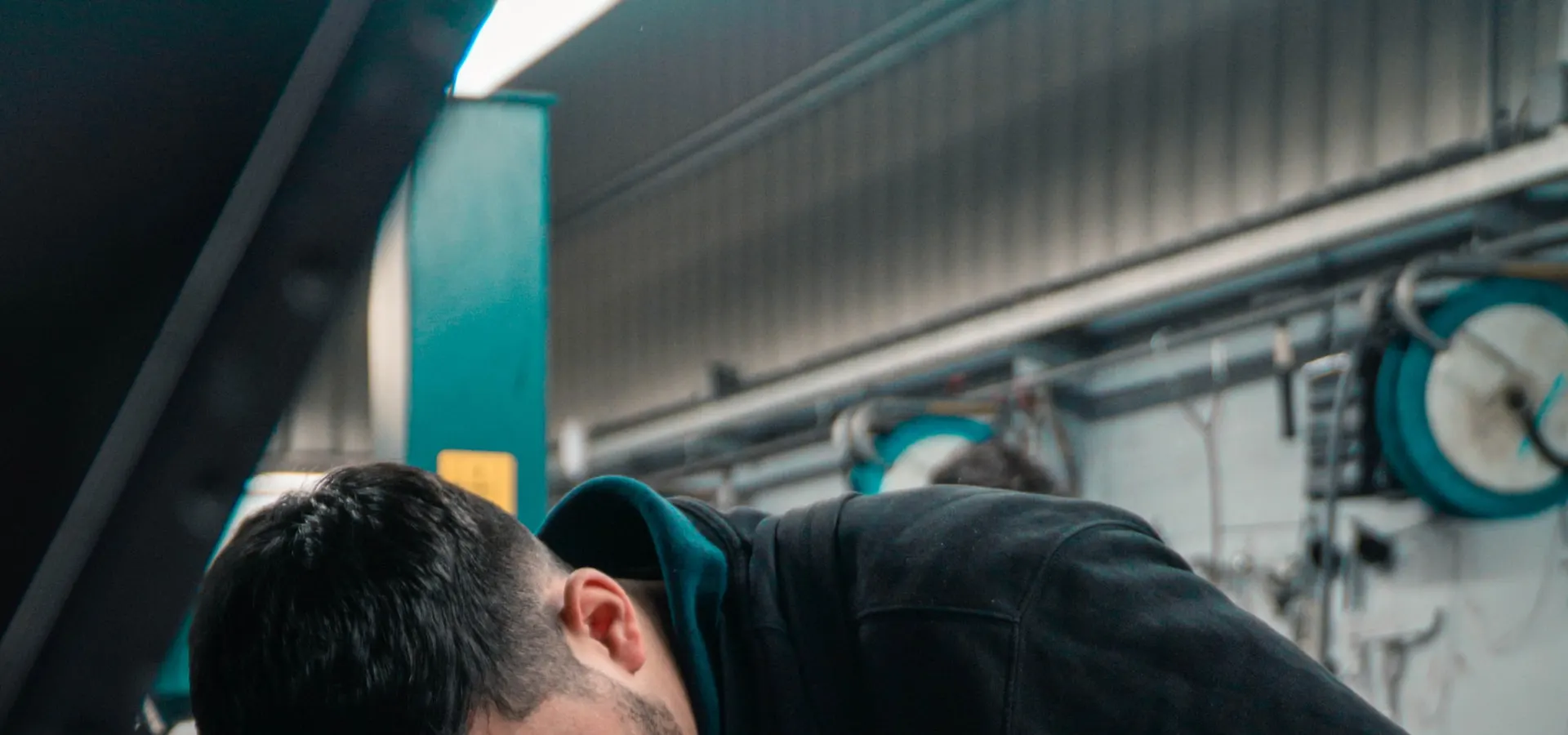 A mechanic working on a car engine in a garage