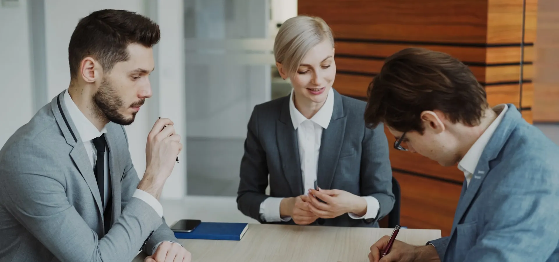 Business professionals reviewing and signing a legal contract
